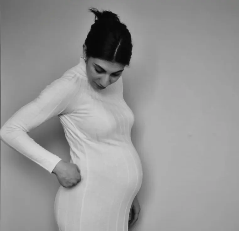 Gravid kvinna som tittar på sin mage